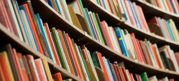 Image of colorful books on a bookshelf with multiple shelves