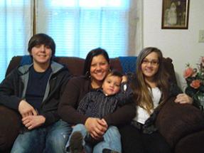 a family sits together on a couch for a photo